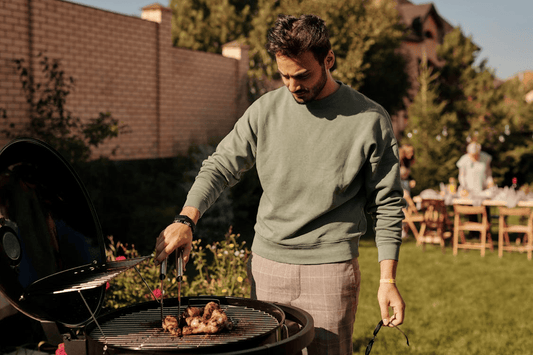 Image of a man outside grilling meat on labour day
