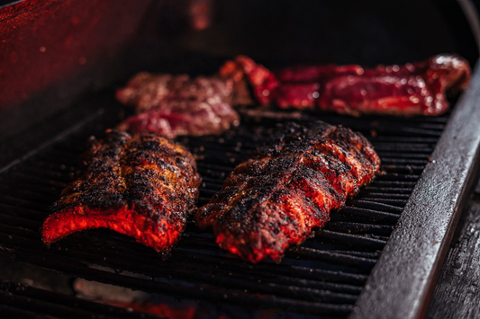 Image of BBQ ribs on a BBQ at night