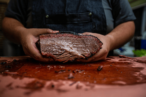 Man holding a large roast on a cutting board