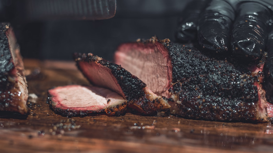 Image of BBQ brisket being cut on a wooden cutting board