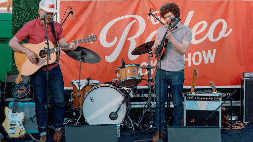 Two band members play at a rodeo show during the summer