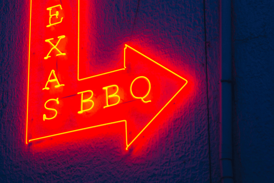 A Texas BBQ near sign in red with a black background
