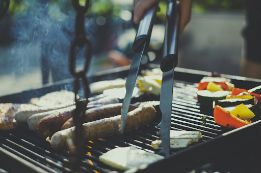 a outdoor bbq grill full of assorted meat and veg on a sunny day