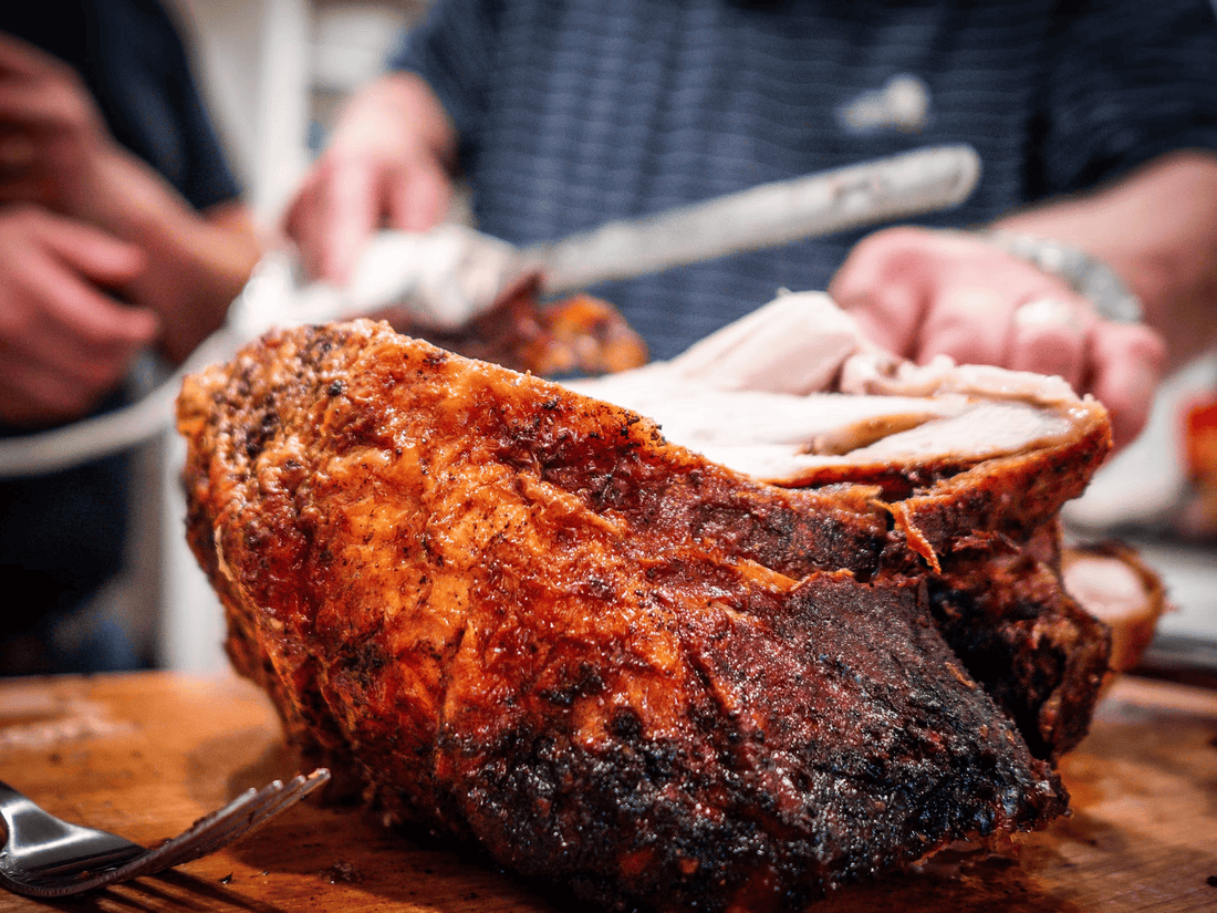 Man carves a juicy turkey on a wooden cutting board