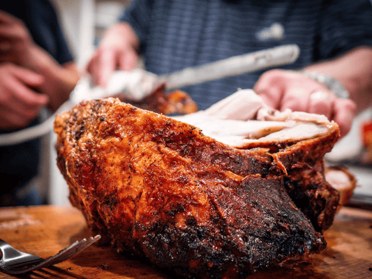 Man carves a juicy turkey on a wooden cutting board