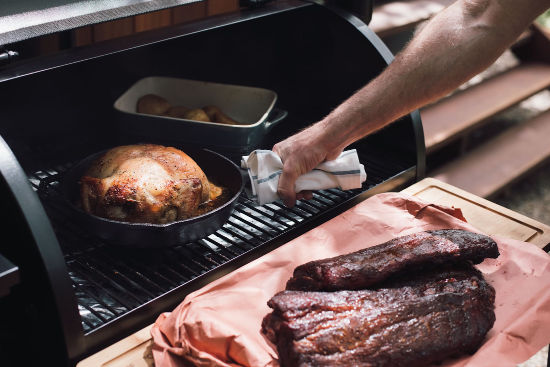 Man puts different kinds of BBQ meat on an outdoor bbq